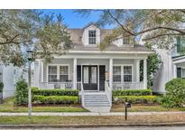 Charming home featuring a covered front porch with white columns and well-maintained landscaping at 610 Nadina Pl, Celebration, FL 34747