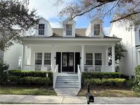 Charming home with a welcoming front porch, well-maintained landscaping, and classic architectural details at 610 Nadina Pl, Celebration, FL 34747