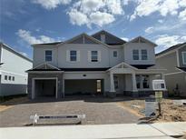 Inviting two-story home boasts a three-car garage and well-manicured front yard at 780 Pointe Emerson Blvd, Apopka, FL 32703