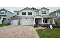 Charming two-story home with stone accents, a three-car garage, and a welcoming front porch at 780 Pointe Emerson Blvd, Apopka, FL 32703
