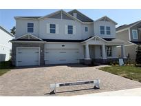 Beautiful two-story home with a brick driveway and three-car garage, offering plenty of space and curb appeal at 780 Pointe Emerson Blvd, Apopka, FL 32703