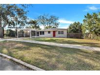 Charming single story home with carport, red front door, and well-maintained lawn at 1202 Ferndell Rd, Orlando, FL 32808