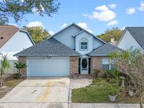 Charming home featuring a brick-accented facade, a well-manicured lawn, and a two-car garage at 3275 Windy Wood Dr, Orlando, FL 32812