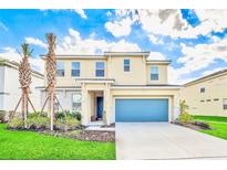 Beautiful two-story home showcasing a well-manicured lawn and a bright blue garage door at 537 Marcello Blvd, Kissimmee, FL 34746