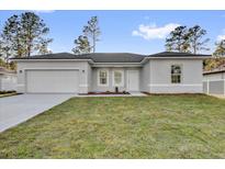 Charming single-story home with a well-manicured lawn, attached garage, and neutral-colored exterior at 773 Marion Oaks Pass, Ocala, FL 34473