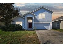 Charming two-story home featuring an attached two-car garage and mature landscaping at 2136 Shadow Creek Dr, Kissimmee, FL 34746