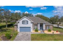 Desirable single-Gathering home with gray paint, well-kept lawn, and elegant landscaping at 3978 Old Dunn Rd, Apopka, FL 32712