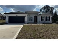 Beautiful single-story home with a two-car garage, modern design, and well-manicured lawn at 4650 Sw 139Th Pl, Ocala, FL 34473