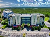Beautiful condo building with lush surroundings and a parking area at 5300 S Atlantic Ave # 6-206, New Smyrna Beach, FL 32169