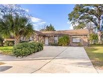 Charming single story home with stone facade, mature trees, and a spacious driveway at 6209 Beaumont Ave, Orlando, FL 32808