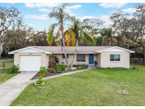 Charming single-story home featuring lush landscaping, a well-manicured lawn, and a welcoming blue front door at 1456 Helena Ct, Deltona, FL 32725