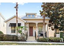 Charming one-story home featuring a cozy porch, elegant columns, and a well-maintained front yard with mature trees at 1990 Appalachee Cir, Tavares, FL 32778