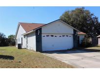 Single Gathering home featuring an attached two car garage and a traditional style roof at 274 W 20Th St, Apopka, FL 32703