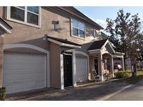 Exterior view of a two-story townhome with attached garages and brick paver street at 3307 Greenwich Village Blvd # 205, Orlando, FL 32835