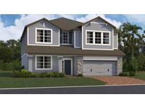 Charming two-story home with blue siding, stone accents, and a welcoming front entrance at 6825 Yellow Warbler Bnd, St Cloud, FL 34773