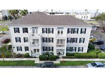 Three story condo building with white siding, dark shutters, and charming private balconies at 770 Siena Palm Dr # 201, Kissimmee, FL 34747