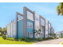 Modern condo building with blue and gray accents, manicured landscaping, and a rooftop deck at 7770 Sandy Ridge Dr # 110, Reunion, FL 34747