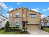 Stunning two-story home featuring stone accents, modern architectural design, and a well-manicured front yard at 9030 Sunshine Ridge Loop, Kissimmee, FL 34747