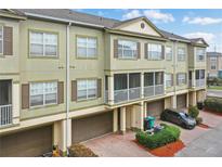 Multi-level townhome features a screened balcony, attached garage and brick-paved driveways at 2352 Grand Central Pkwy # 13, Orlando, FL 32839