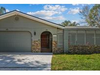 Charming single-story home features stone accents, a well-manicured lawn, and an attached two-car garage at 12442 Sunshine Dr, Clermont, FL 34711