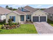 Charming single-story home with a well-manicured lawn, colorful landscaping, and a two-car garage at 18955 Rawson St, Orlando, FL 32827