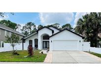 Charming one-story home showcasing a well-maintained lawn, a two-car garage and a welcoming entrance at 322 N Shadowbay Blvd, Longwood, FL 32779