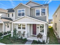 Charming two-story home with covered front porch, chairs, and nicely landscaped yard at 431 Scotsmans Pl, Debary, FL 32713