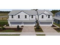 Charming two-story townhomes featuring light gray exteriors, white trim, and individual garages, perfect for modern living at 6689 Horseshoe Lane Way, St Cloud, FL 34773