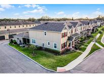 An aerial view of a meticulously landscaped townhome community showcasing the well-maintained lawns and exteriors at 696 Orange Belt Loop, Winter Garden, FL 34787