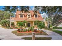 Charming two-story home featuring a beautiful landscape design, elegant windows and a tile roof at 7655 Debeaubien Dr, Orlando, FL 32835