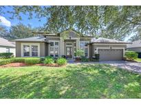 Charming single-story home with well-maintained lawn, mature landscaping, and a two-car garage at 814 Kazaros Cir, Ocoee, FL 34761