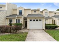 Charming townhouse featuring a one-car garage, landscaped front yard, and a welcoming entryway at 832 Westshore Ct, Casselberry, FL 32707