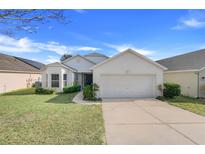 Charming single-story home with well-maintained landscaping and a two-car garage at 1047 Bluegrass Dr, Groveland, FL 34736