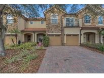 Charming townhome with a stone facade, two-car garage, and a well-manicured front yard at 10509 Belfry Cir, Orlando, FL 32832