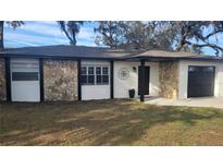 Charming single-story home featuring stone accents, black trim, and an attached single car garage at 11801 Lake Susan Ct, Clermont, FL 34711