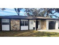 Charming home featuring stone accents, dark trim, and a neatly manicured lawn at 11801 Lake Susan Ct, Clermont, FL 34711