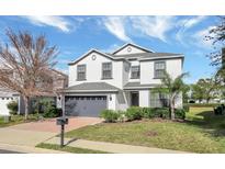 Charming two-story home featuring a gray roof, two-car garage, and manicured front lawn at 2383 Victoria Dr, Davenport, FL 33837