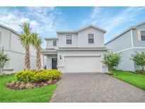 Charming two-story home featuring a two-car garage, landscaped yard, and fresh exterior paint at 2483 Dubai St, Kissimmee, FL 34747