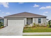 Charming single-story home with a two-car garage, well manicured lawn, and landscaped front yard at 545 Jerry Ln, Haines City, FL 33844