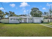 Charming home showcasing a well-manicured lawn, light gray exterior paint, and decorative front door at 5844 Bamboo Dr, Orlando, FL 32807