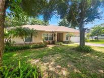 Charming single-story home boasts a lush landscaped yard with mature trees and a cozy, inviting facade at 1224 Shorecrest Cir, Clermont, FL 34711