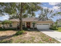 Charming single-story home with manicured landscaping, attached two-car garage, and inviting front entrance at 1224 Shorecrest Cir, Clermont, FL 34711