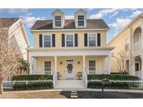 Charming yellow two-story home with a welcoming front porch and black shutters at 206 Norfolk Pl, Kissimmee, FL 34747