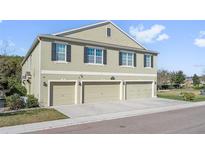 Modern three-story townhome featuring a three-car garage and manicured landscaping at 3422 Seneca Club Loop # 57, Orlando, FL 32808