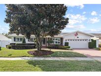 Charming single-story home with manicured lawn, brick driveway, and attached two-car garage at 625 Brechin Dr, Winter Park, FL 32792