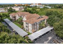 A charming condo building with lush landscaping and covered parking spots at 7123 Yacht Basin Ave # 328, Orlando, FL 32835