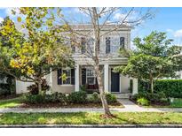 Charming home with a well-maintained lawn, landscaping, and inviting front porch at 14214 Shocklach Dr, Winter Garden, FL 34787