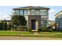 Inviting two-story home with a modern facade, well-maintained landscaping, and a striking blue front door at 16249 Taliesin St, Winter Garden, FL 34787