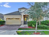 Charming one-story home with a brick driveway, two car garage, and decorative stone front columns at 2890 Avian Loop, Kissimmee, FL 34741