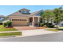 Charming single-story home featuring a brick driveway, two-car garage, and well-manicured landscaping at 2890 Avian Loop, Kissimmee, FL 34741